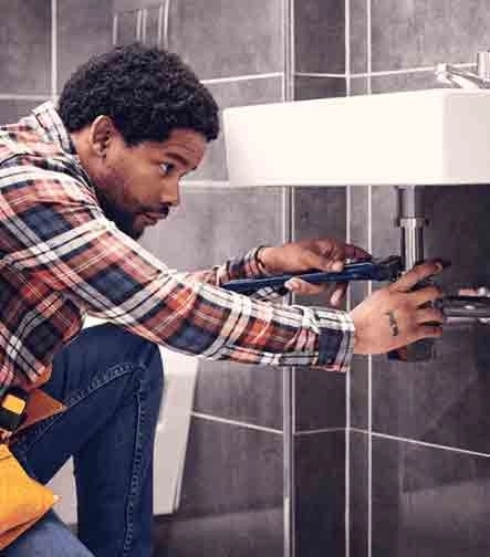 Profesional realizando trabajo de plomería en un baño