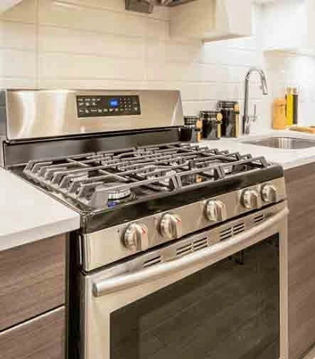 Cocina moderna con encimera de cuarzo y electrodomésticos de acero inoxidable